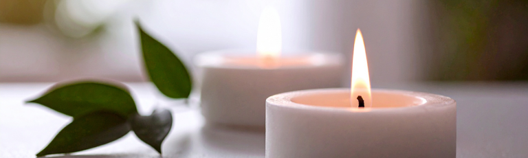 Bougies allumées et plante verte dans un intérieur zen épuré, symbolisant la patience, le retour à soi et l'alignement intérieur sans action