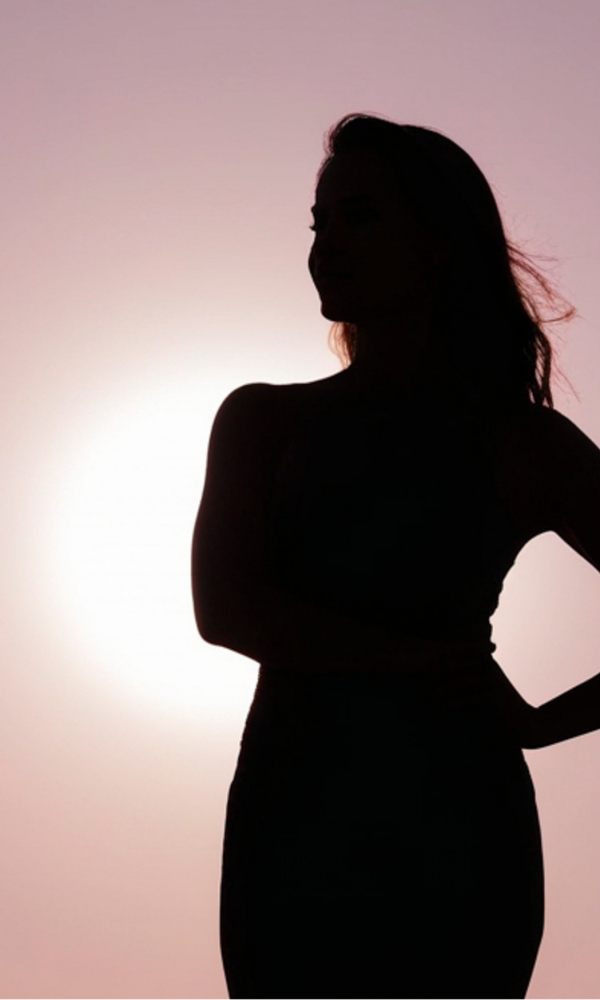Femme hypersensible sereine et ancrée dans une lumière dorée qui pose ses limites pour protéger et booster son énergie vitale